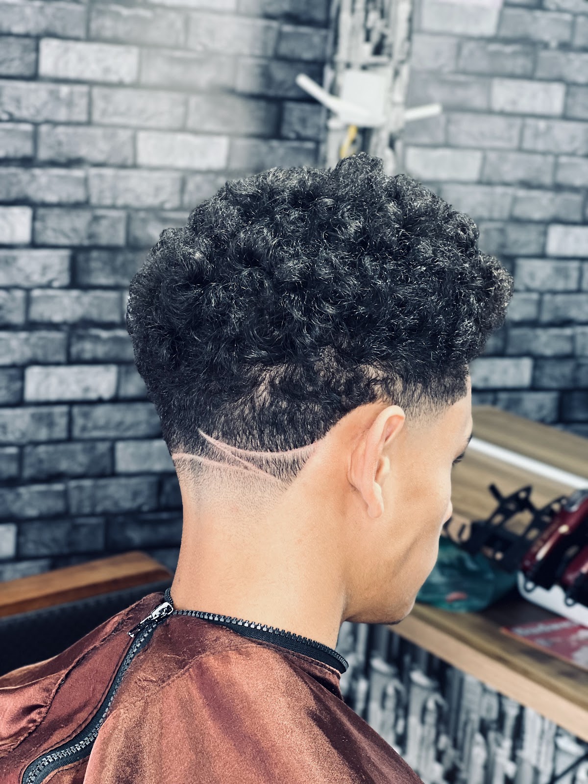 Corte em cabelo cacheado, visto de trás, na Renatobarber